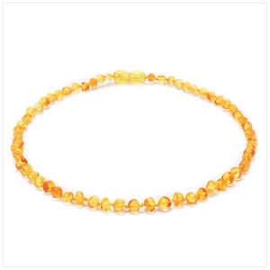 Detailed close-up of rounded Baltic amber beads on a child's necklace with white background