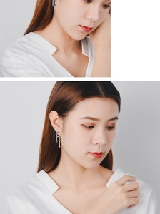 Detail of moon dangle earrings featuring sparkling blue stones and tassel design