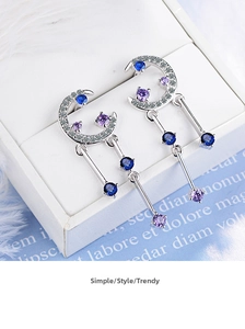 Detailed view of silver crescent moon drop earrings with blue and purple zircons