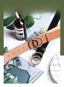 Flat lay of brown and black leather belts with vintage bronze double ring buckles