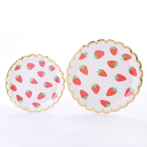 Detail of strawberry print paper plates with scalloped gold foil edges for party use