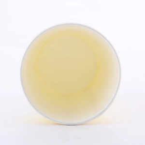 Top-down macro view of a single disposable paper cup with yellow rim for birthday parties