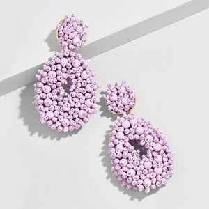 Macro detail of lavender beaded bohemian drop earrings with gold metal base and oval pendants