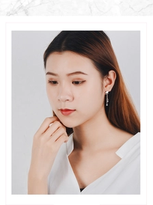 Close-up of elegant star tassel earrings with silver beads on a female model