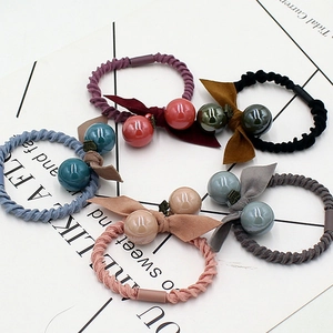 Lot de cinq élastiques tressés colorés avec perles doubles et nœuds en tissu