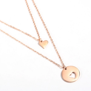 Detail view of rose gold layered necklace featuring hollow heart and round pendants