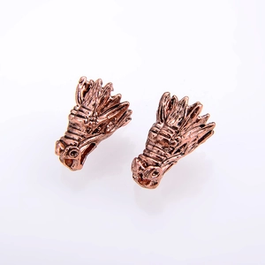 Detailed view of vintage bronze dragon head charms with intricate scale textures