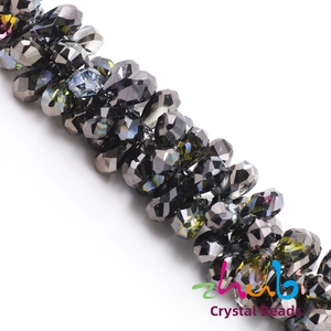 Macro shot of dark grey teardrop crystal beads with iridescent faceted surface for DIY