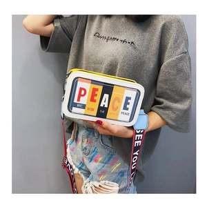 Détail du petit sac carré avec imprimé PEACE et bandoulière large colorée tendance