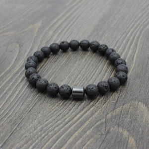 Macro shot of natural porous black volcanic lava stone beads and dark metal cylinder bead
