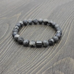 Detailed view of natural tiger eye and black stone beaded bracelet on dark wood surface