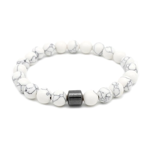 Detailed shot of white marble stone beads and a dark gray metallic cylinder charm bracelet