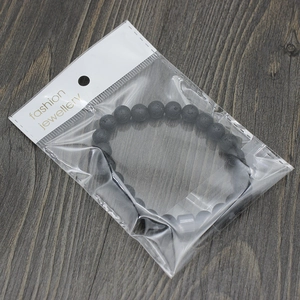 Detail eines schwarzen Lavastein-Armbands in einer Schmuck-Verpackung aus Plastik