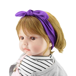 Detail of a soft purple knotted rabbit ear headband displayed on a baby doll model