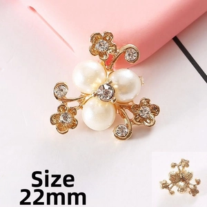 Dettaglio di un ciondolo a fiore con perle da 22mm, cristalli e finitura in oro