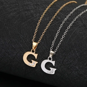Detailed view of capital G pendant necklaces in gold and silver finish with small crystals