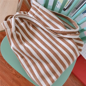 Detail view of thick brown and white striped canvas tote bag texture and wide strap