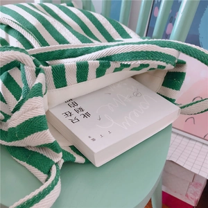 Close-up of green and white striped canvas tote showing thick texture and interior capacity