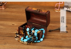 Internal view of vintage wooden jewelry box with colorful beaded necklaces and metal latch