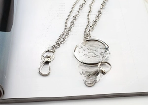 Detail of a punk style multi-layer silver metal chain with lobster clasps and ring