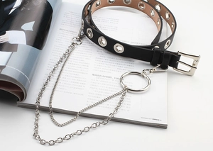 Detail of black leather belt with silver eyelets, metal chain and large round ring buckle