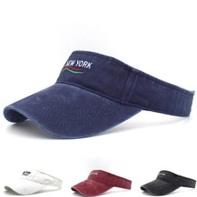 Detail view of the embroidered New York logo and washed fabric texture on navy visor hat
