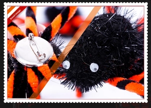 Macro detail of Halloween black and orange spider brooch with metal pin fastening