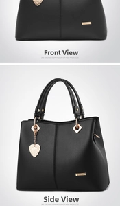 Detail of black tote bag with lychee texture, golden heart charm, and metallic hardware