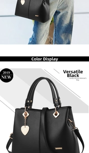 Detail view of black faux leather tote bag with heart pendant and adjustable strap