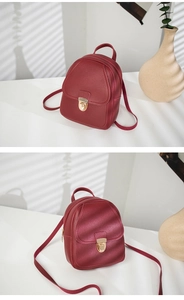 Detail of burgundy PU leather mini backpack with golden metal buckle clasp closure