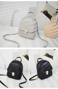 Detailed view of mini PU leather backpacks in black and grey with gold metal buckle