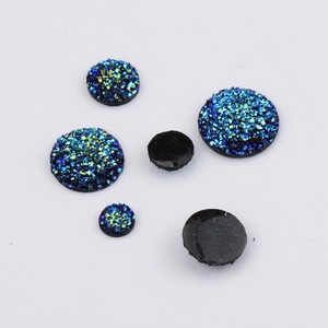 Flatback resin druzy stones with blue glitter texture and black glossy finish on white base