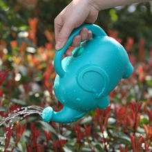 Blue elephant-shaped watering can detail for garden use showing realistic water droplets