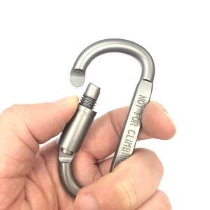 Macro detail of gunmetal grey D-ring carabiner with screw lock and safety warning