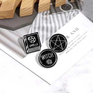 Three-piece punk enamel pins set featuring black and white witch spell book and star designs
