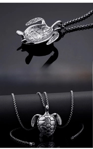 Detailed view of turtle pendant in polished steel with textured shell and black chain