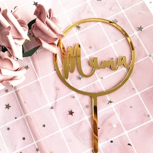 Golden acrylic mirror Mama cake topper on pink mesh with decorative flowers and stars