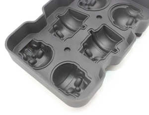 Macro detail of black food-grade silicone mold featuring six skull-shaped ice tray cavities