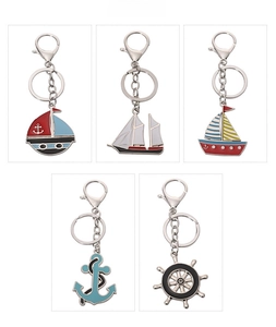 Detailed view of metal nautical keychains featuring enamel sailboat, anchor and helm charms