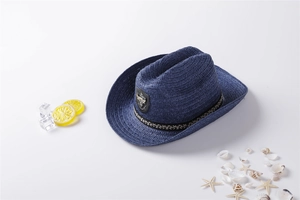 Detail of dark blue straw fedora with ethnic band and bull head ornament on beach decor