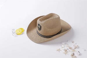 Macro shot of straw sun hat with ethnic band and vintage cattle head emblem decoration