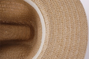 Macro detail of natural straw hat interior showing woven texture and inner sweatband