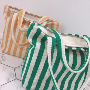 Detail view of thickened striped canvas tote bags in yellow and green with wide handles