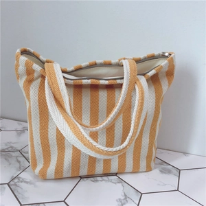 Close-up of yellow and white striped canvas tote bag with zipper and thick texture