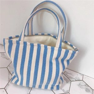 Detailed view of the blue and white striped canvas tote bag with zipper and lining