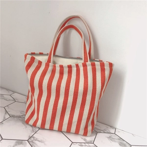 Detail of orange and white striped canvas tote bag with reinforced grey edging