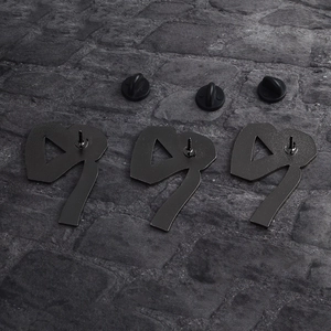 Three creative matte black metal number 9 brooches with rubber clasps on stone background