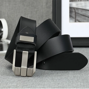 Close-up of black genuine leather belt with a silver pin buckle on a textured surface