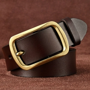 Close-up of a dark brown leather belt with vintage brass buckle on a soft suede surface
