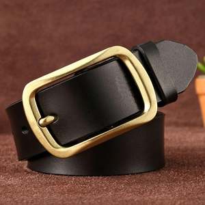 Detailed view of black genuine leather belt with a vintage brass buckle on brown background